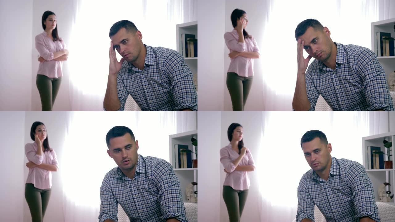 家庭误会，与妻子吵架后失望的配偶坐在家里折叠手靠近脸和女人站着