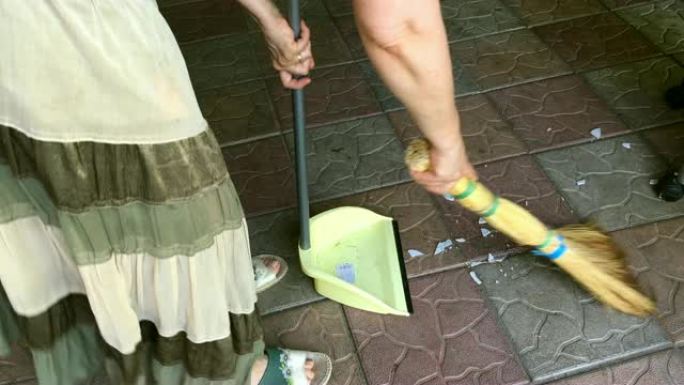 女人用扫帚扫除碎片。