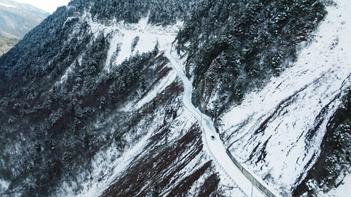 航拍一辆汽车行驶在白雪山路崎岖安全驾驶