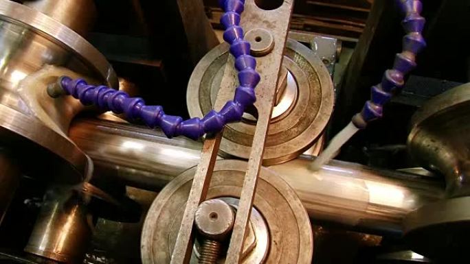 在工厂生产金属钢管的金属轧制机器的特写。
