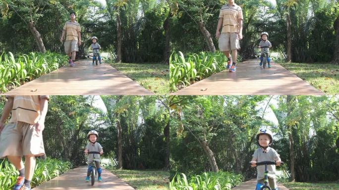 亚洲蹒跚学步的男孩戴着安全帽的孩子在阳光明媚的夏日学习骑第一辆平衡自行车