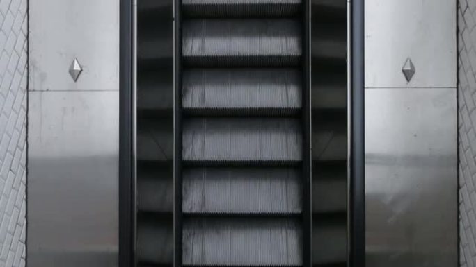 地铁自动扶梯的俯视图。男子上自动扶梯