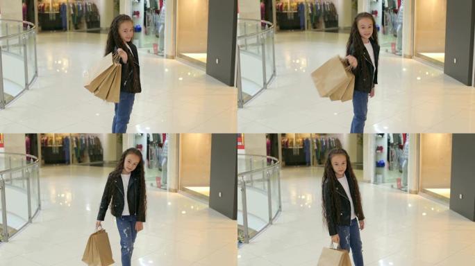 购物中心里一个可爱的小女孩的肖像，自动扶梯附近有包裹
