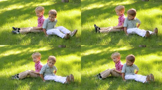 两个有趣的小男孩在公园的绿草地上玩耍。暑假。