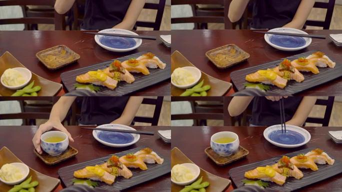 亚洲女性喜欢在午餐时间在日本餐厅吃日本寿司和绿茶