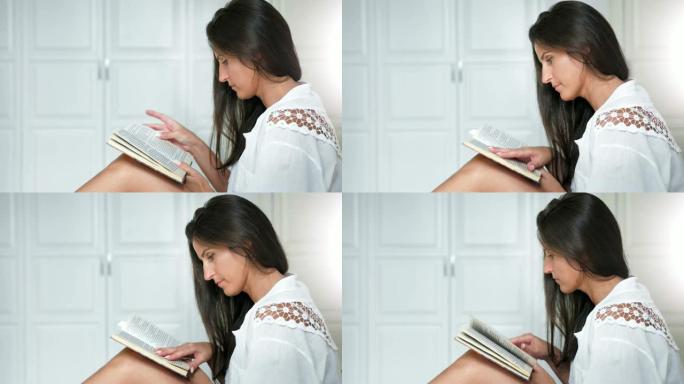 侧视图高加索迷人的沉思女人热情地在家看书