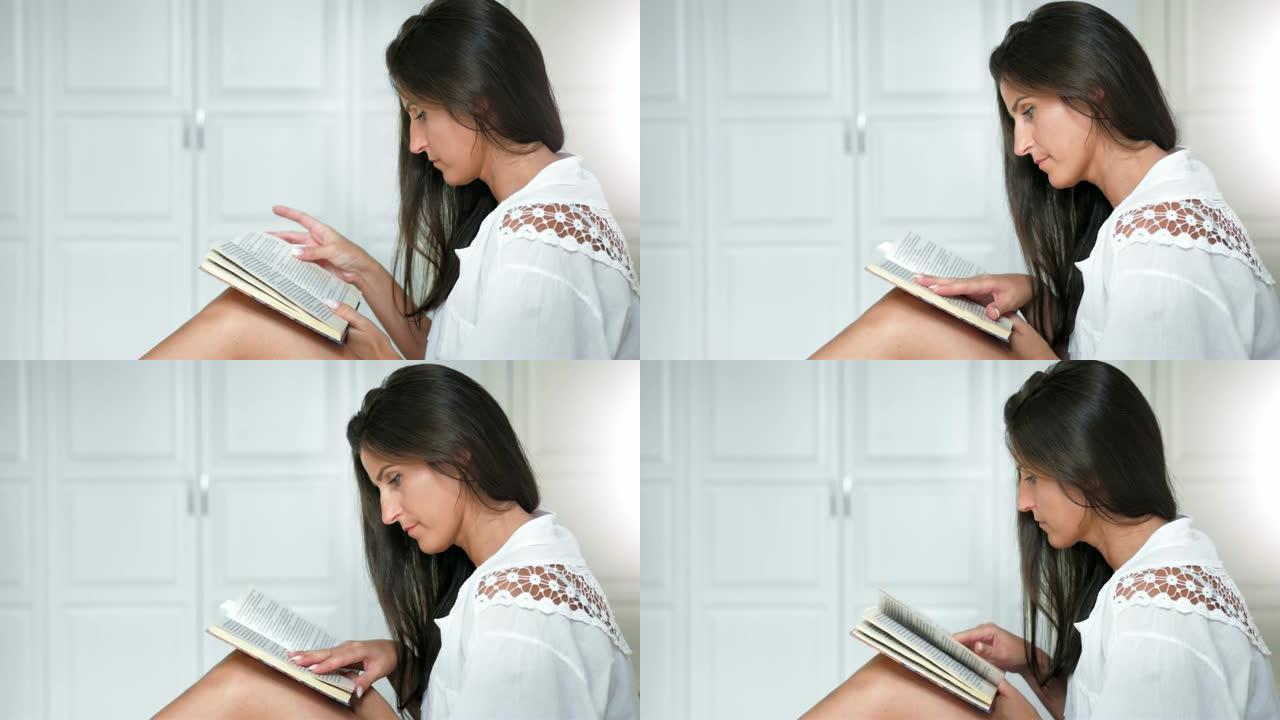 侧视图高加索迷人的沉思女人热情地在家看书
