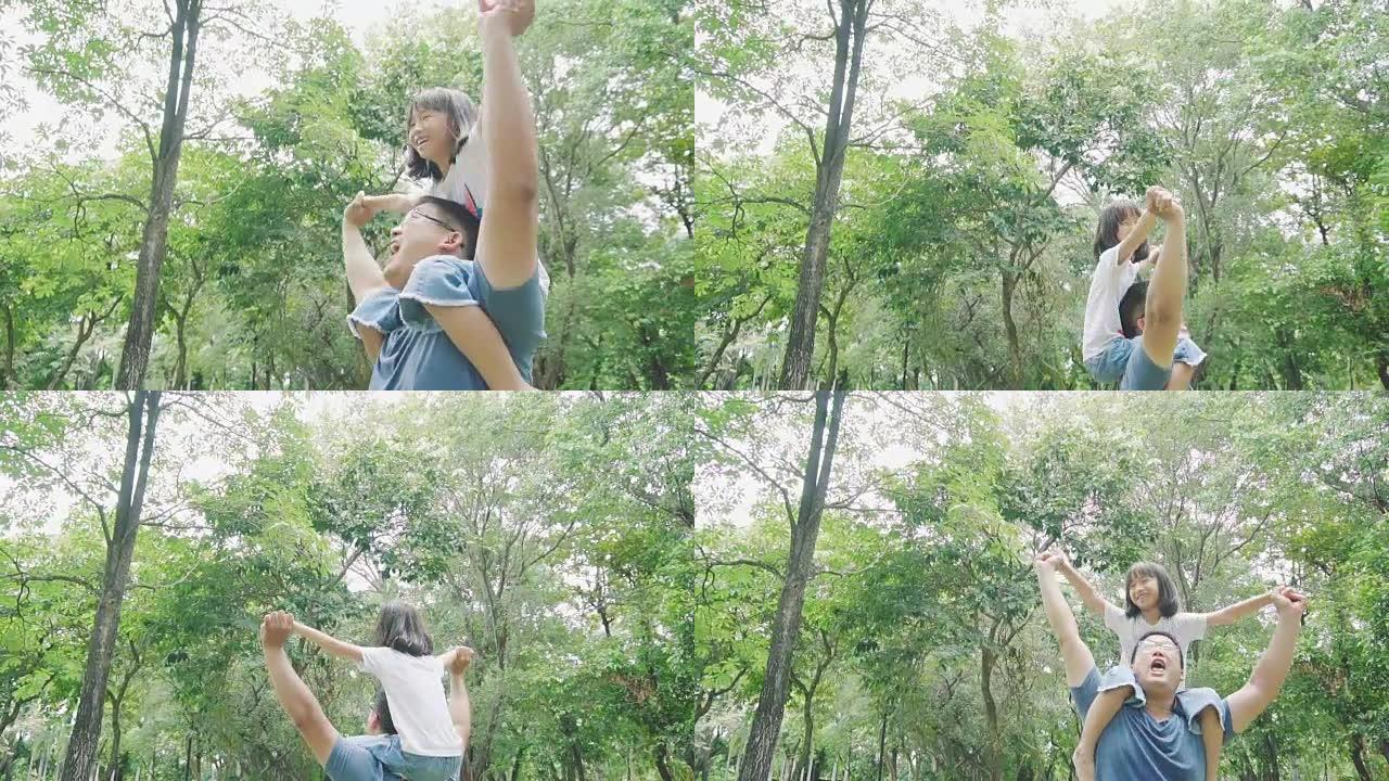 亚洲女儿在公园里快乐地骑着父亲的脖子。