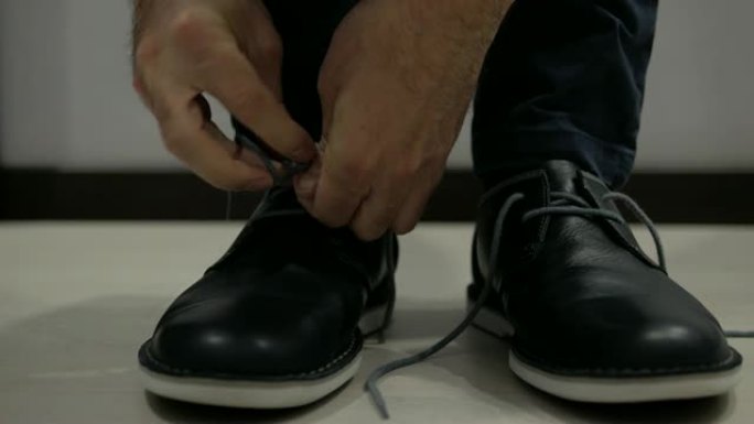 男人解开皮鞋上的鞋带