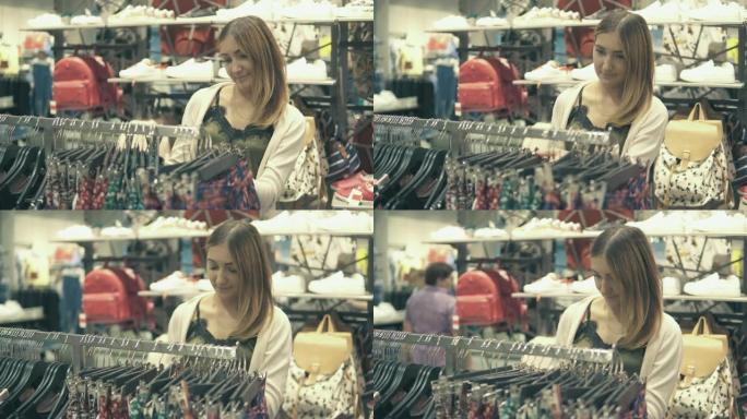 年轻漂亮的女人在时尚商场购物，选择新衣服。