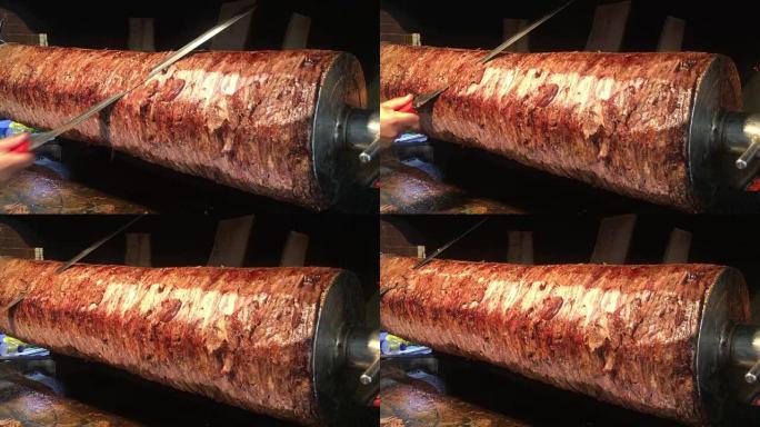 一位厨师用锋利的大刀切烤肉串，土耳其烤肉串在烤架上转动