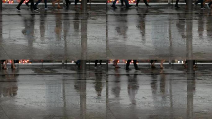 许多人在雨天穿着湿鞋在城市里下雨倒影