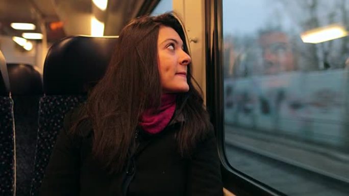 乘火车旅行的勇女人凝视着路过的风景。坐在移动火车上的女孩以4k慢动作向外看