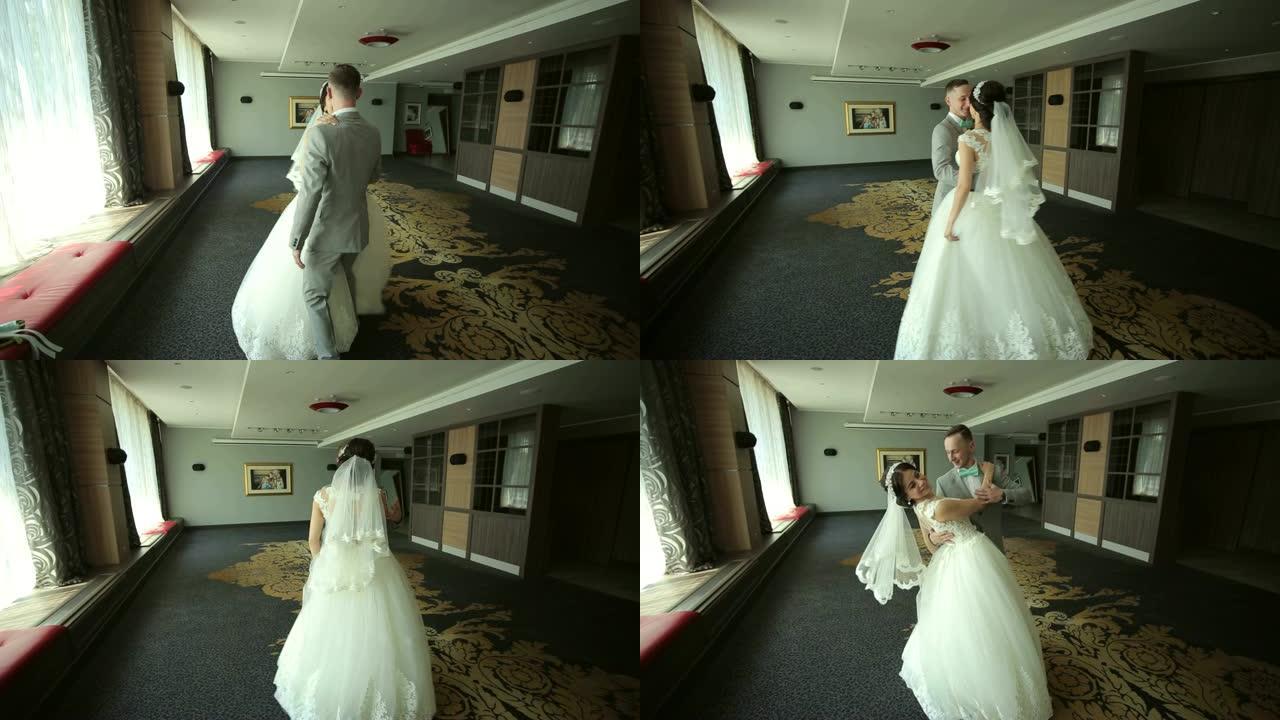 幸福的新婚夫妇在一个拥有美丽现代室内的房间里跳华尔兹舞。