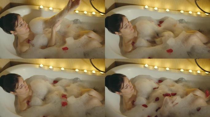 美女用泡沫和玫瑰花瓣洗澡