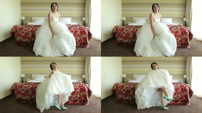新娘坐在床上展示她的鞋子，把裙子伸直在裙子上。