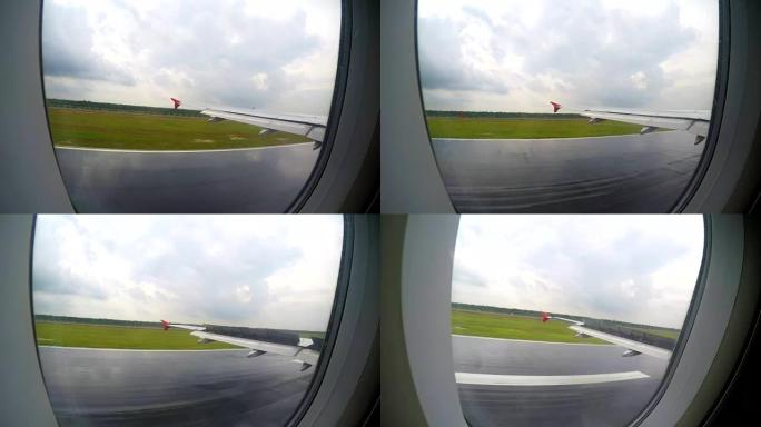 从飞机机翼上的窗户看，飞机低空飞到地面并降落在机场