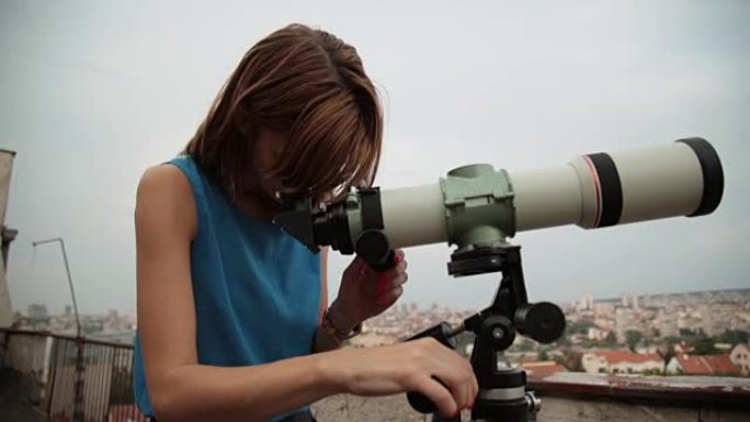 年轻女子用天文望远镜看着天空。