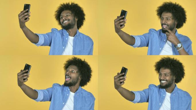 非洲裔美国人在黄色背景上使用智能手机自拍