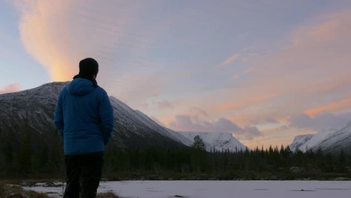 一个男人，一个中年运动员，在山里遇见黎明。他欣赏太阳和湖中群山的倒影。