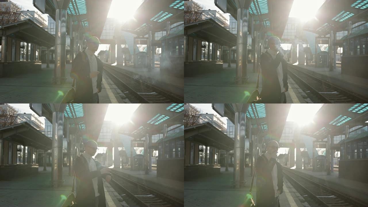 这位戴着眼镜的男子肩上扛着一个包，站在火车站的站台上等待晚点的火车。
