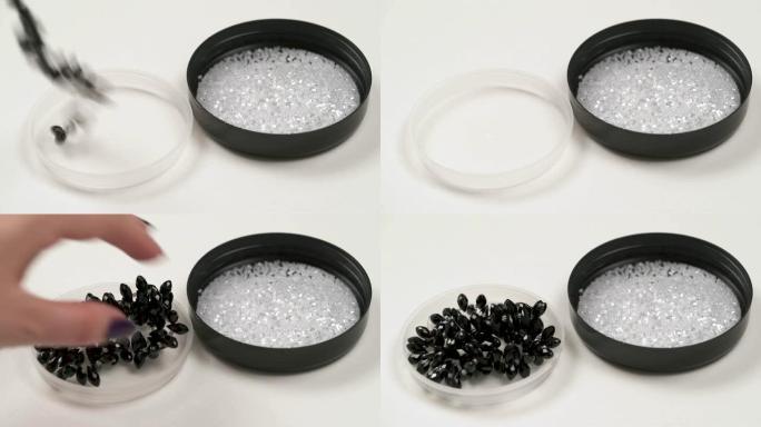 两个圆形盖子的特写镜头，右边是水晶珠，左边是黑色串珠。女人的手从白色的盖子上拿出一根黑色的绳子，然后
