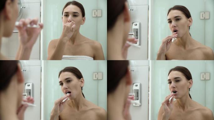 牙齿健康。女人在浴室刷牙