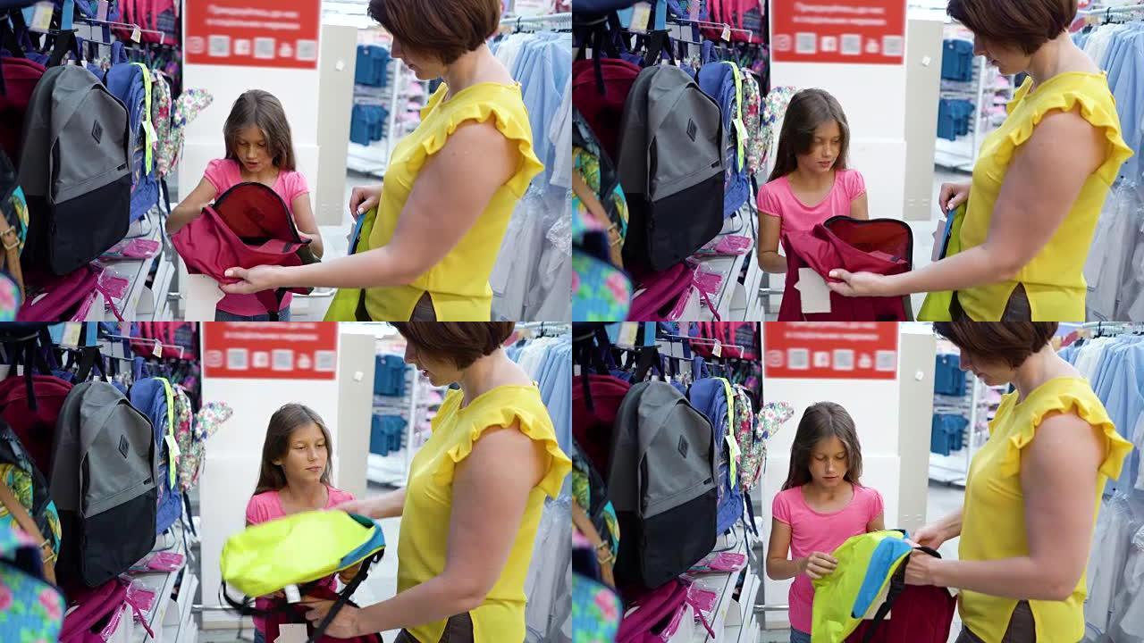 商店货架附近的高加索母女在小百货市场选择书包背包