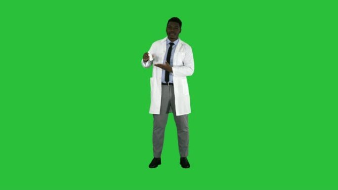 微笑的医生或医生在绿色屏幕上呈现鼻腔喷雾，色度键