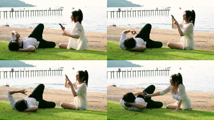 浪漫情侣在海滩上用智能手机拍照