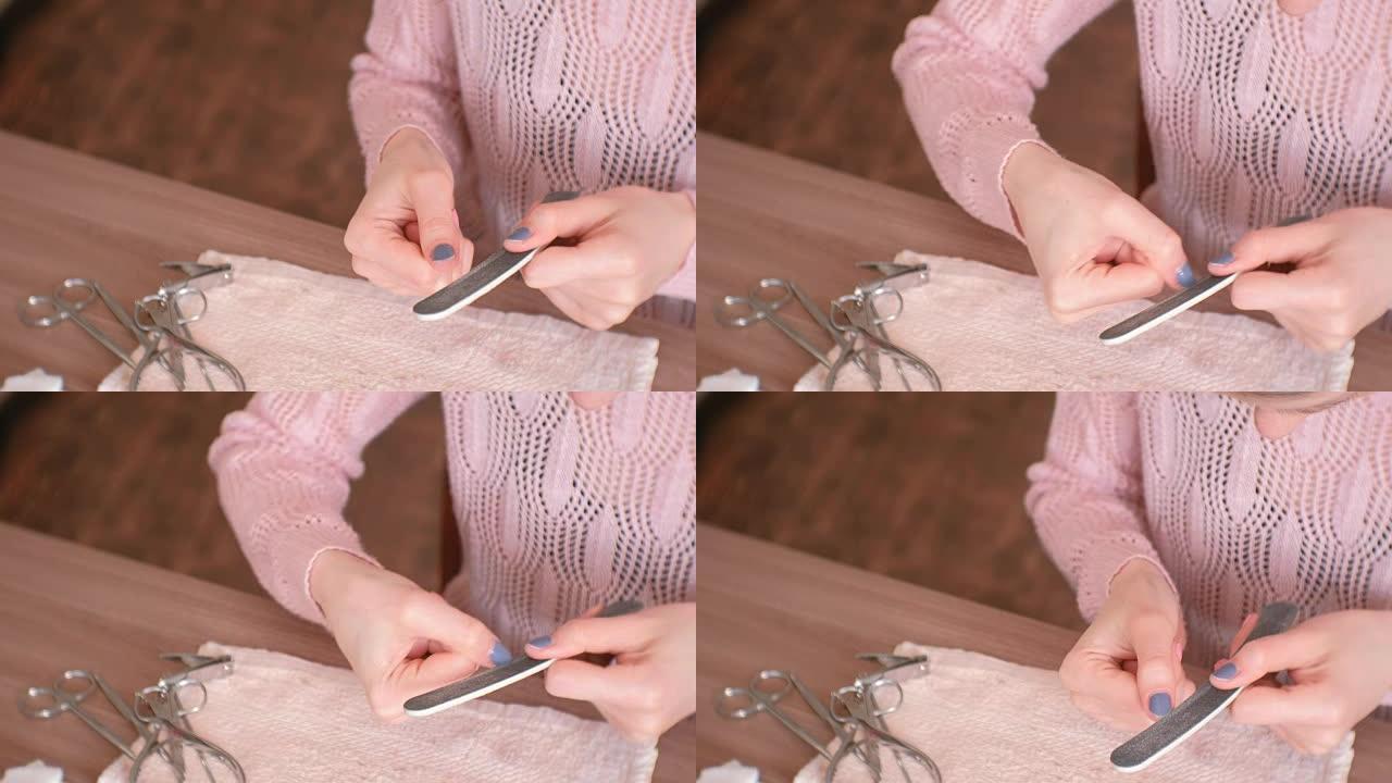 女人文件钉子指甲锉。特写手。桌子上的工具