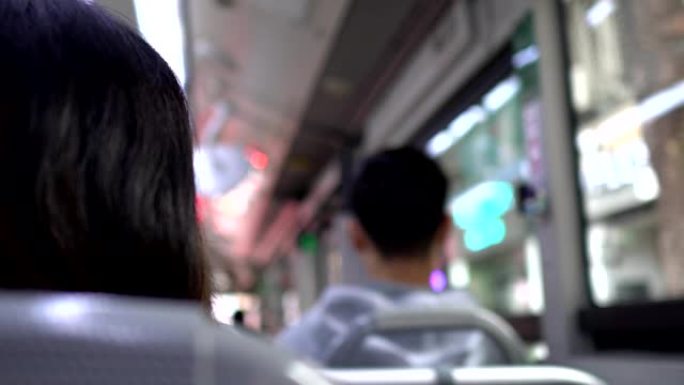 乘客的背部，在摇晃的公共汽车上。