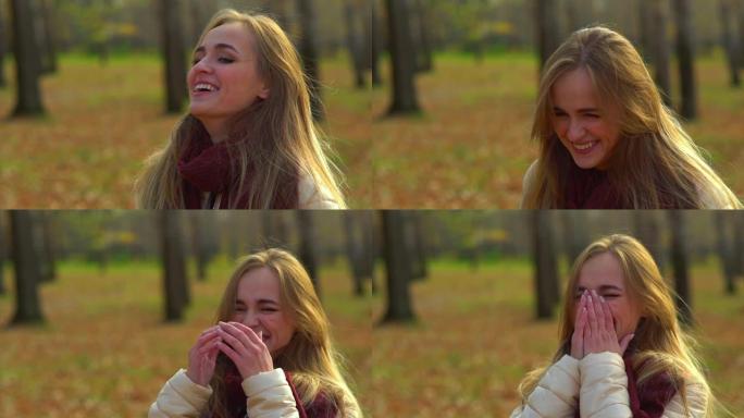 年轻迷人的女孩在秋季公园大笑。