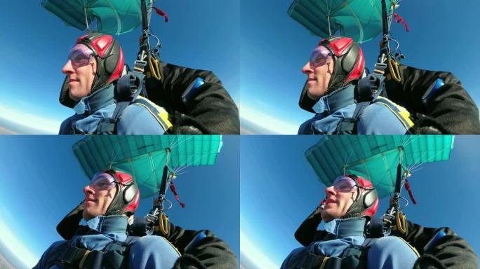 跳伞运动员在敞开的降落伞下一前一后飞行。慢动作