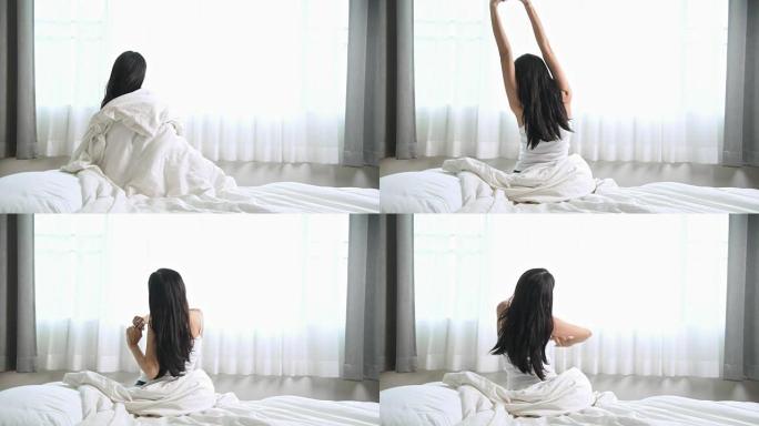 女人醒来。躺在床上的亚洲女人醒来伸展身体。