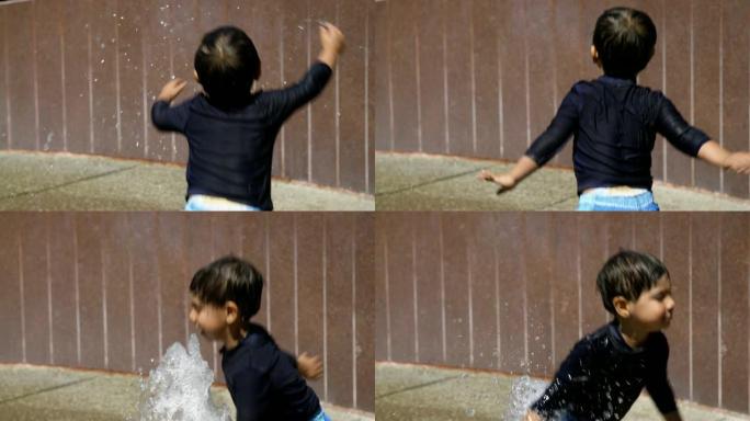 小男孩在喷泉里飞溅