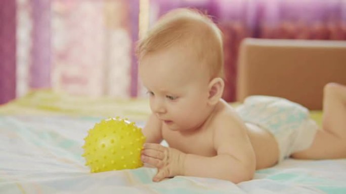 一个漂亮的婴儿在撒谎。他手里拿着球玩