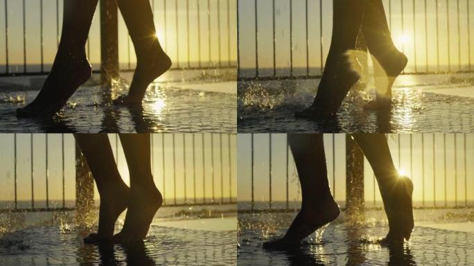淋浴时性感女人腿的特写镜头。日落时的热带户外淋浴。