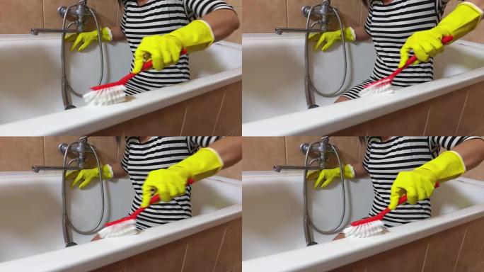 戴黄色手套的女人用红色刷子清洁浴缸