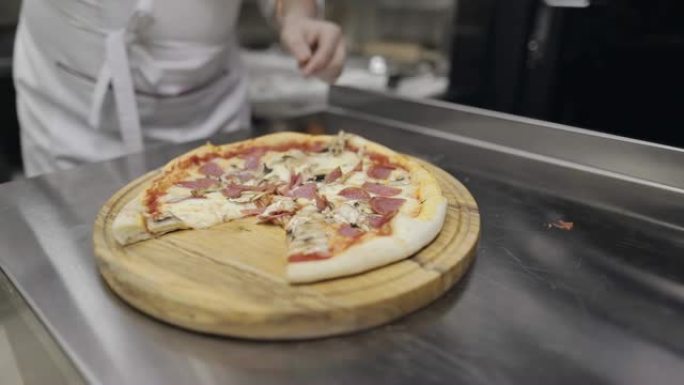 香肠披萨配蘑菇、西红柿和奶酪。厨师拿了一块披萨