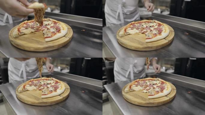 香肠披萨配蘑菇、西红柿和奶酪。厨师拿了一块披萨
