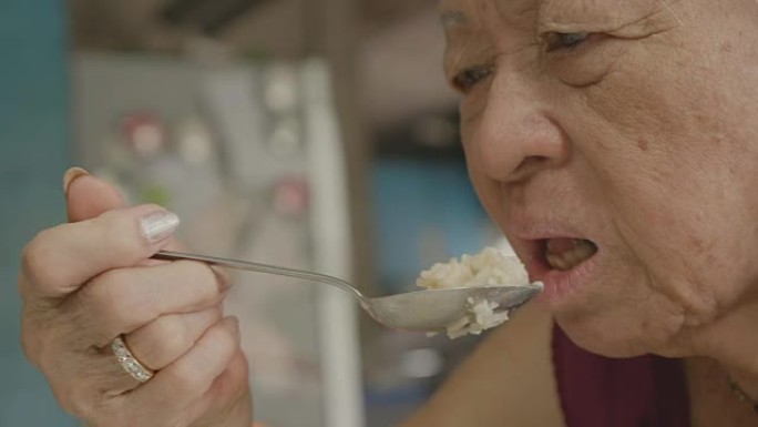 资深亚洲女性在家吃食物。