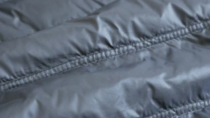 暖冬羽绒服男士派克大衣4K 2160p 30fps超高清镜头闪亮合成表面缓慢倾斜-管壁填充夹克的特写