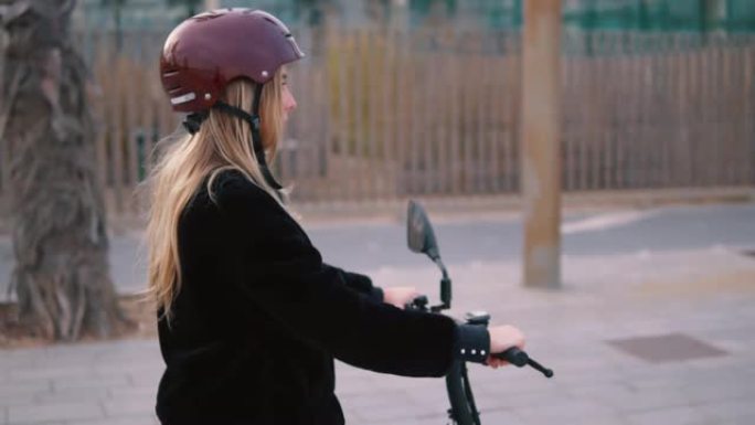 漂亮的金发女人在城市里驾驶电动自行车