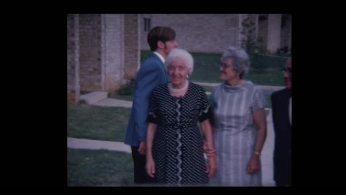 穿着蓝色燕尾服的1971毕业男孩与祖父母合影