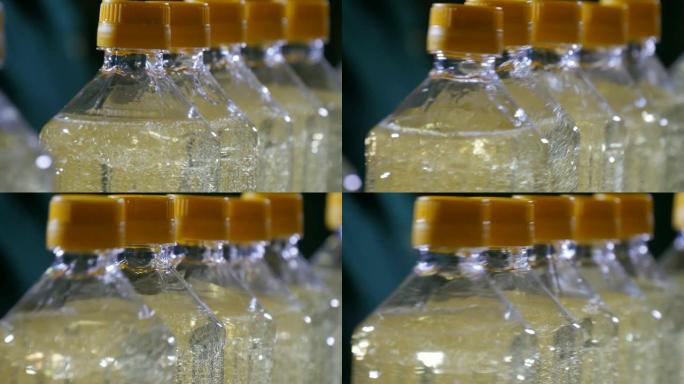 瓶装葵花籽油在黑色背景下在传送带上快活。