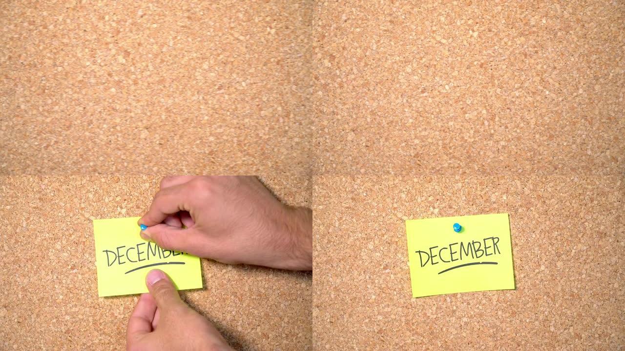 一个男人钉在软木板上的纸上12月字