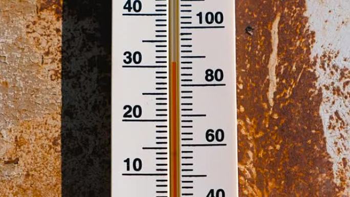 生锈的墙壁上的温度计显示30度的热量。