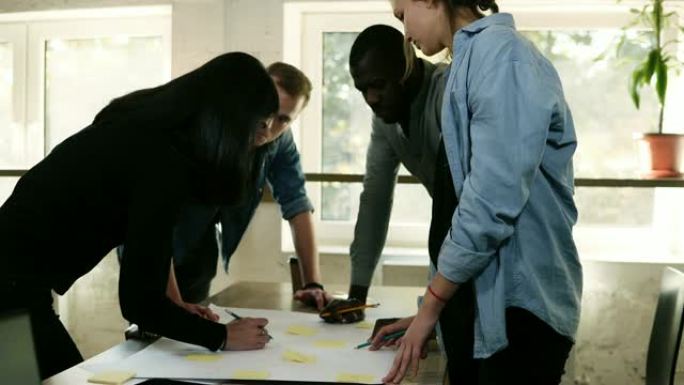 黑白一群人在办公室一起讨论一个项目。计划步骤，用黄色贴纸指着桌子，写笔记。明亮的工作场所。加速镜头