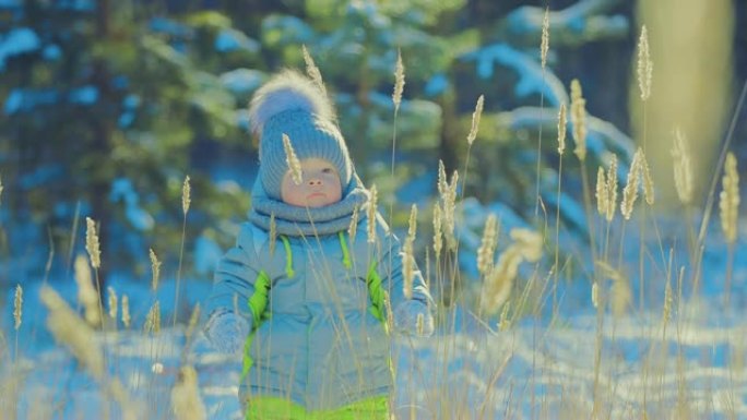 漂亮的宝贝站在雪地里环顾四周。冬日。特写